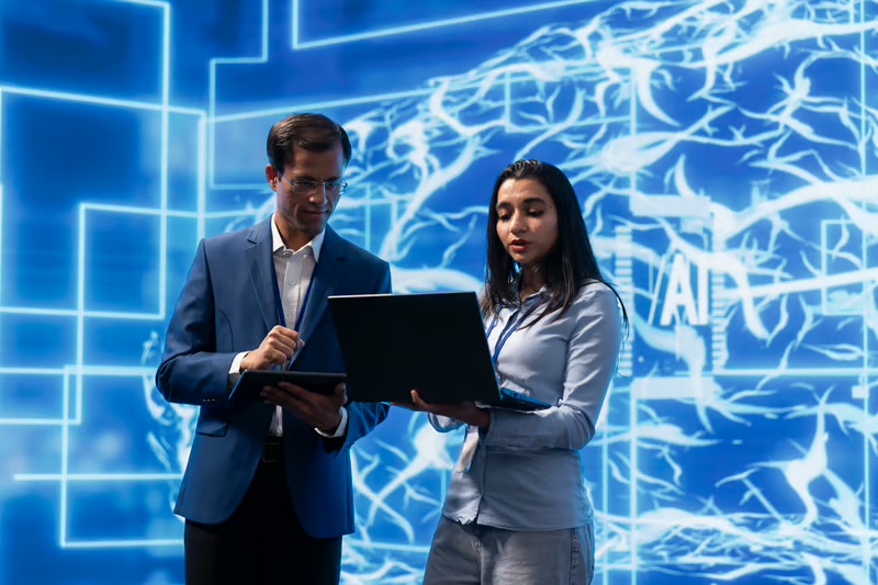 Business professionals collaborating with AI technology to support human-centered decision-making in the workplace.